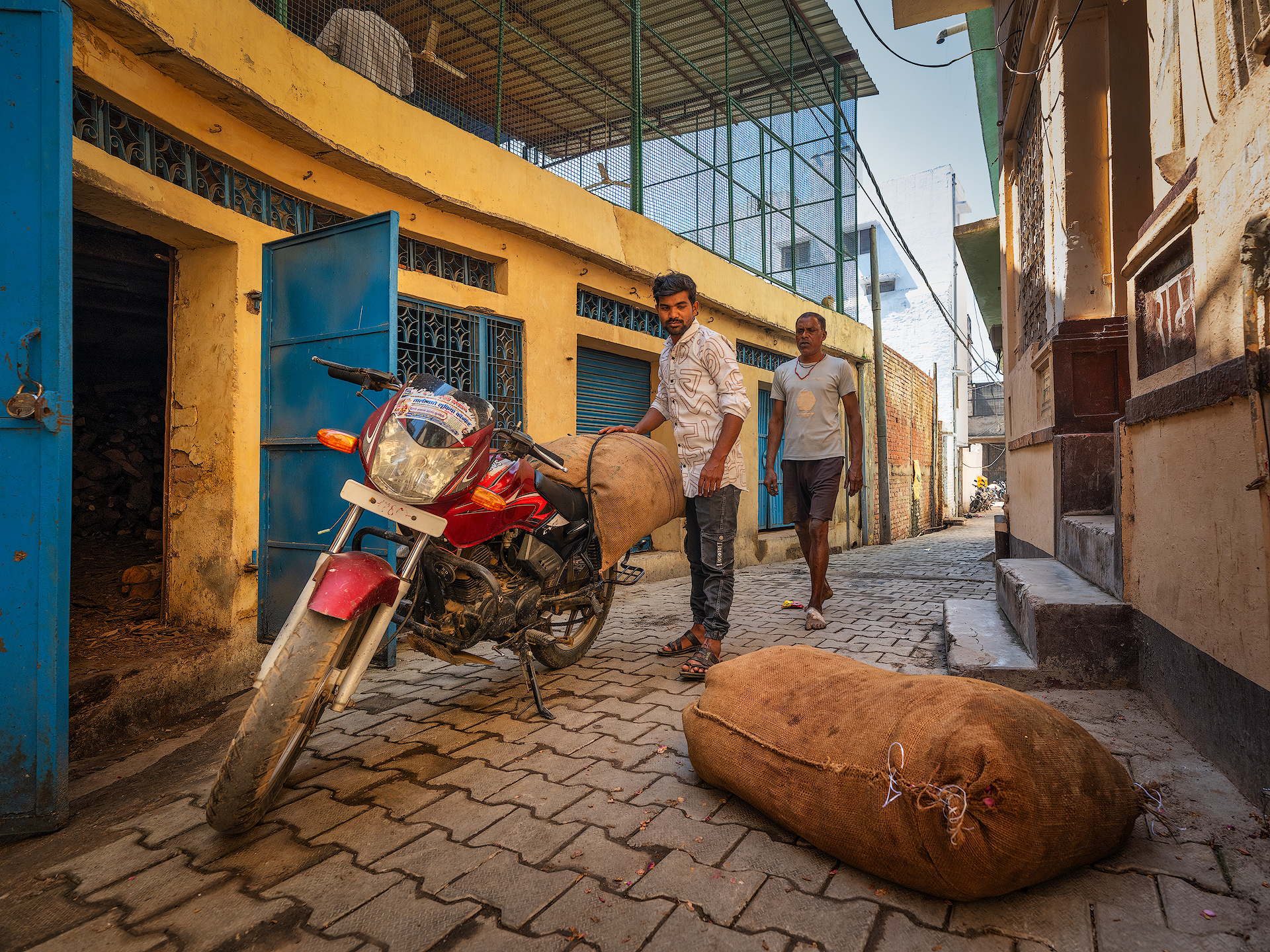 In Kannauj, roses are harvested early in the morning when the flowers are still fresh and full of fragrance. After picking, the petals are placed in jute sacks and transported to local distilleries. There, the sacks are weighed to determine the exact quantity. If the quality of the roses is good and the price offered by the distillery owner is acceptable, the petals are purchased. Otherwise, if the price is considered too high, the sacks are reloaded and taken to another distillery in search of a better offer.