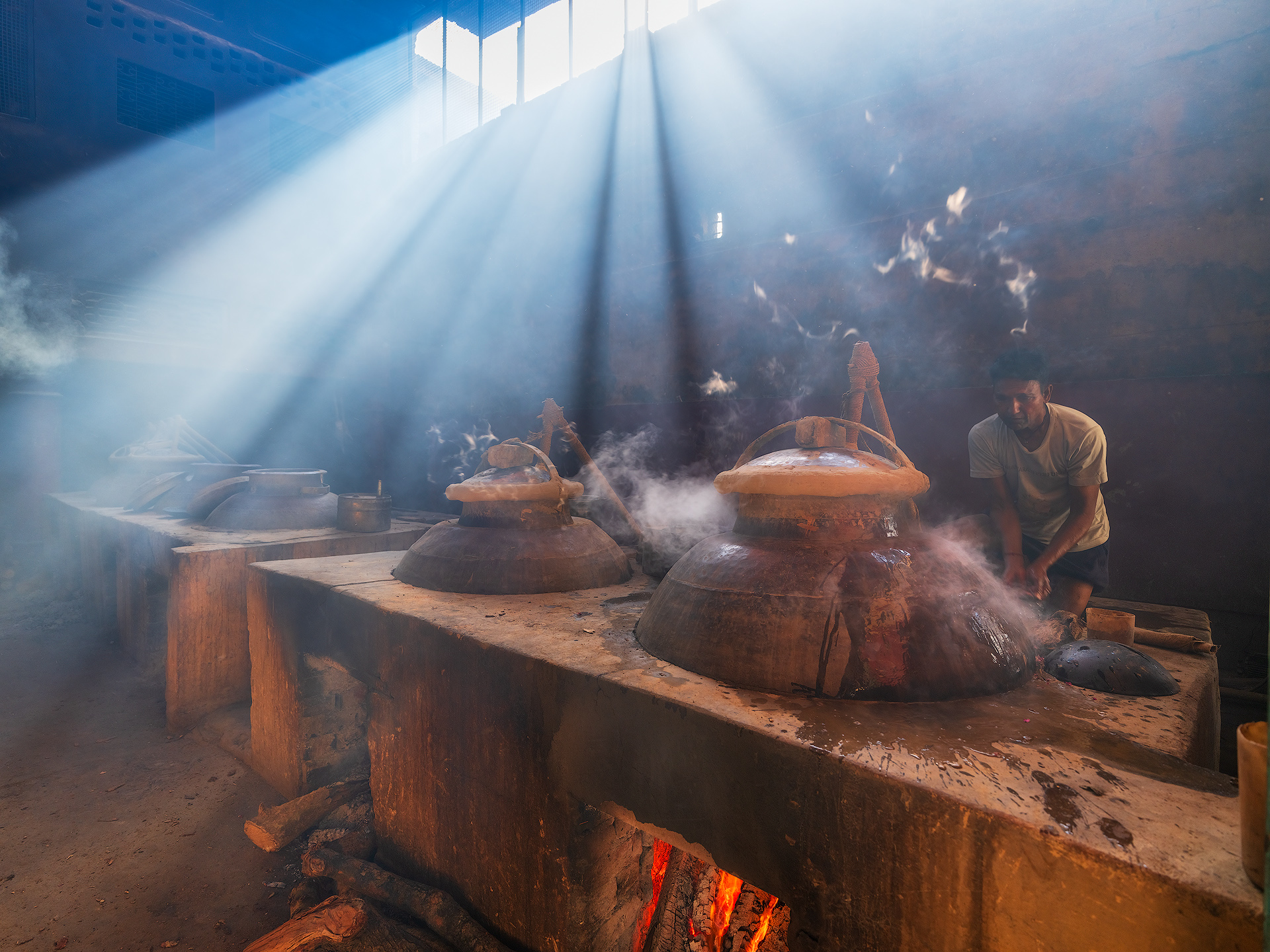 In case the deg—the copper cauldron used in the distillation—becomes overheated, the experienced worker can intervene quickly by placing cloths soaked in cold water on top of the deg or around the sealed area. This method helps to rapidly lower the internal temperature, temporarily slowing down or halting the evaporation of the essential oils. The goal is to prevent damage to the raw material (such as burning the petals) and to preserve the quality of the final essence. This kind of intervention requires great skill and attention, as it must be carefully balanced with the need to maintain a steady and continuous distillation process.